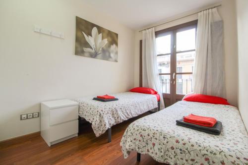 1 dormitorio con 2 camas y ventana en Girona 108, en Barcelona