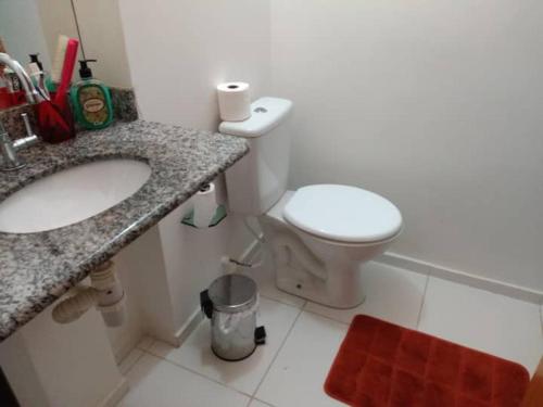 ein Badezimmer mit einem weißen WC und einem Waschbecken in der Unterkunft Casa no Condomínio Naturalle in Mangaratiba