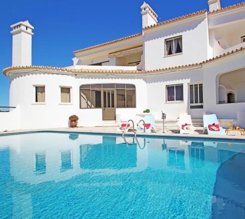 a villa with a swimming pool in front of a house at Apartment Capri by Algarve Vacation in Albufeira