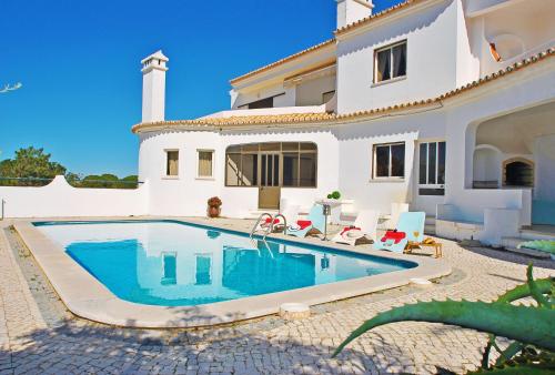 a villa with a swimming pool in front of a house at Apartment Capri by Algarve Vacation in Albufeira