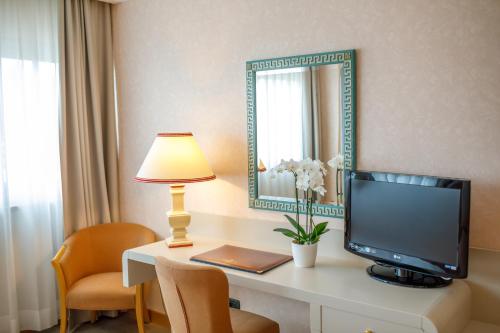 a room with a desk with a television and a mirror at Perugia Plaza Hotel in Perugia