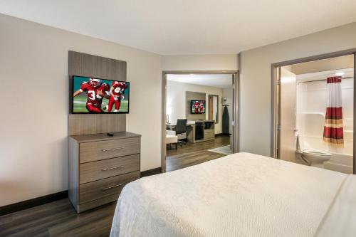 a bedroom with a bed and a tv on the wall at Red Roof Inn PLUS+ Boston - Logan in Saugus