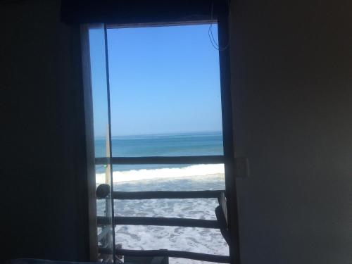 a door leading to the beach with a view of the ocean at Mancora Apartments in Máncora
