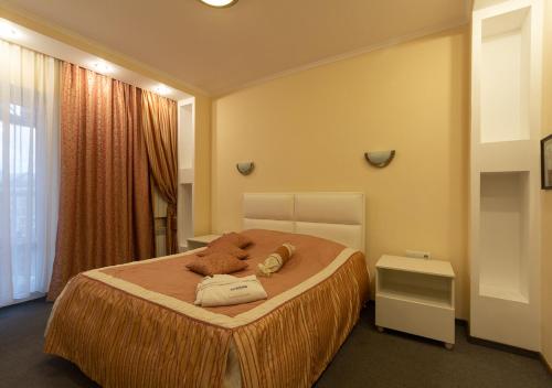 ein Schlafzimmer mit einem Bett mit zwei Teddybären darauf in der Unterkunft Kozatskiy Hotel in Kiew