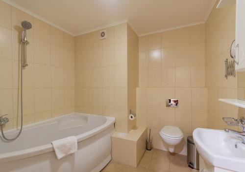 a bathroom with a tub and a toilet and a sink at Kozatskiy Hotel in Kyiv