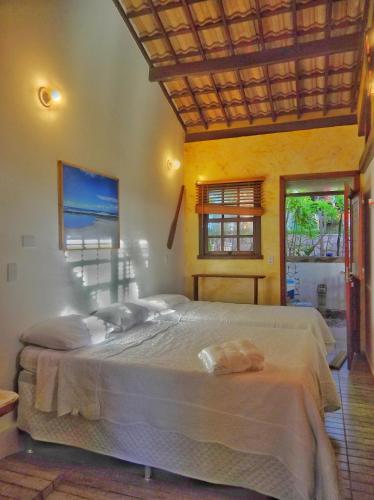 a bedroom with two beds and a window at Vila Bello Pontal in Coruripe