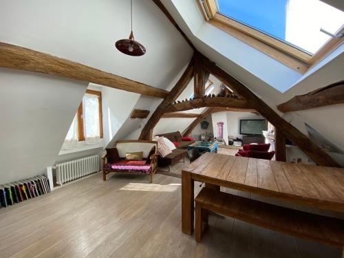 a living room with a vaulted ceiling with wooden beams at Appart'hôtel Paris Roland-Garros in Boulogne-Billancourt
