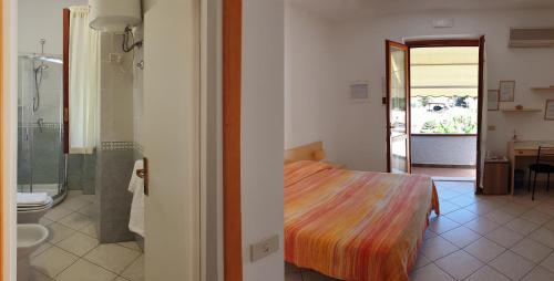 a bedroom with a bed and a bathroom with a shower at Villa dei Limoni in SantʼAndrea