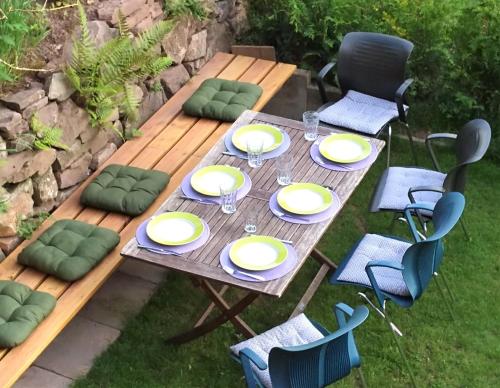 a wooden table with yellow plates and chairs at Ferienwohnung Tischneck in Schramberg