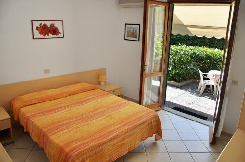 サンタンドレーアにあるVilla dei Limoniのベッドルーム1室(ベッド1台付)、スライド式ガラスドアが備わります。