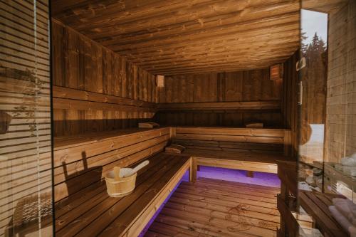 an empty wooden sauna with a bucket in it at Cabana Bucin in Bucsin