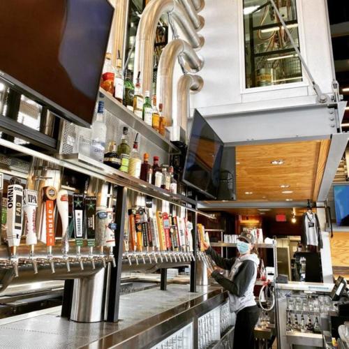 a person standing at a bar with a mask on at Holiday Inn Express Hotel & Suites Rogers by IHG in Rogers