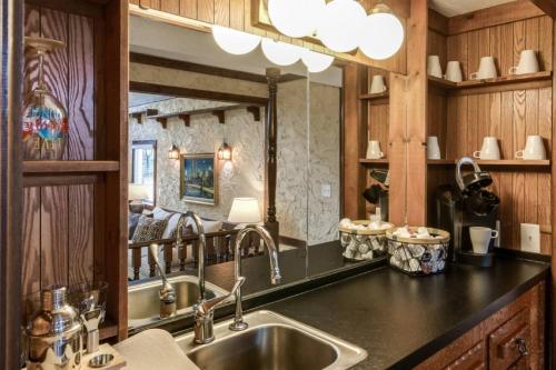 eine Küche mit einem Waschbecken und einem großen Spiegel in der Unterkunft English Cottage Pool Home Florida Style in Orange Park