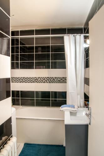 une salle de bain avec une baignoire, un lavabo et une douche dans l'établissement Flozed, à Beauvais