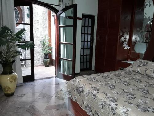 1 dormitorio con 1 cama y puerta abierta en Gallardin Palace Hotel, en Petrópolis