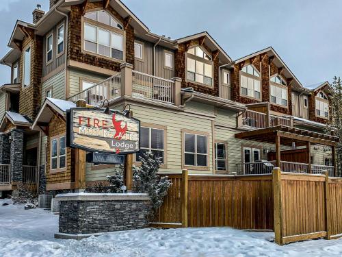 a large house with a sign in the snow at Spacious Mountain 2 Bedroom with Hot tub managed by Little Sister Getaways in Canmore
