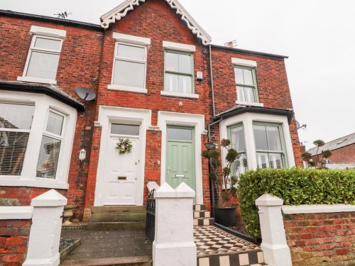 a red brick house with a green door at Westwood House in Lytham St Annes