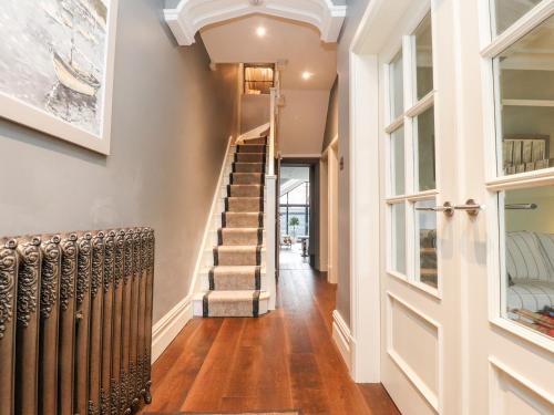 a hallway of a house with a wooden floor and stairs at Westwood House in Lytham St Annes