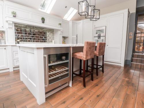 a kitchen with a bar with a fireplace and two chairs at Westwood House in Lytham St Annes