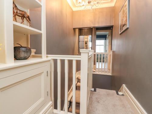 a home hallway with a staircase and a chandelier at Westwood House in Lytham St Annes