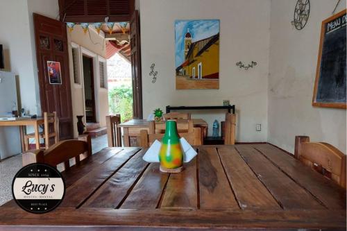 Casa Lucys Hostal في غرناطة: طاولة خشبية عليها مزهرية