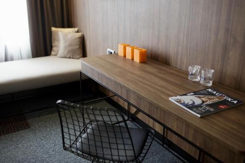a room with a desk with a bed and a table at Rtanj Kopaonik Eco Resort & Spa in Kopaonik