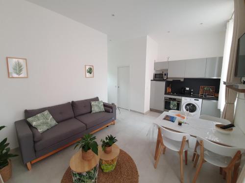 un salon avec un canapé et une table dans l'établissement La Canopée Superbe 2 pièces neuf à 100m de la plage Classé 2 étoiles, à Menton