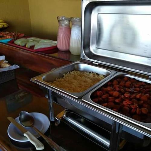 a buffet with a tray of food on a table at Pousada Espirito do Mar in Cabo Frio