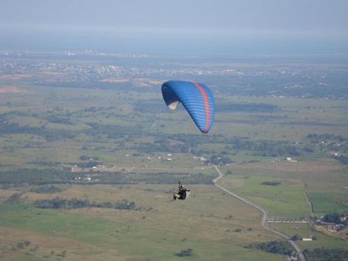a person flying a parachute in the air at Quitinete em Itaguaí in Itaguaí