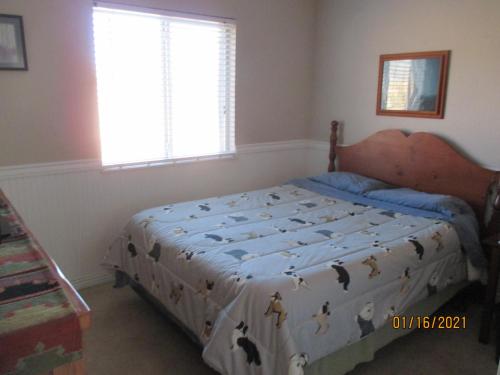 a bedroom with a bed with a comforter on it at Peaks Wildernest House Bed and Breakfast - Vaccinations Required in Flagstaff