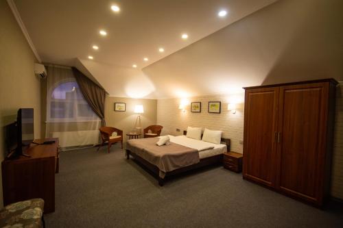 une chambre d'hôtel avec un lit et une télévision dans l'établissement Три Сімки, à Vychhorod