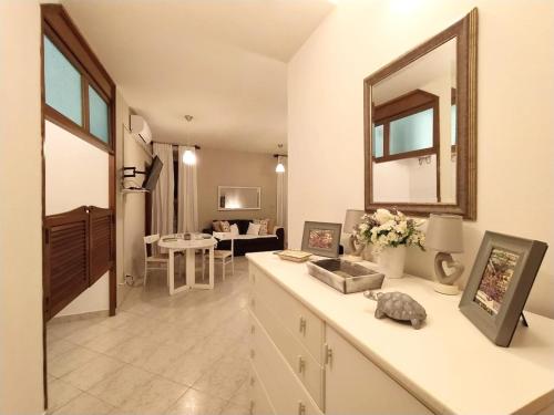 a kitchen with a living room with a mirror and a counter at A due passi dal mare in Moneglia