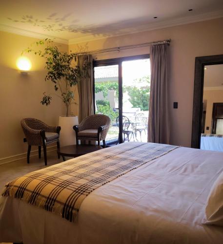 a bedroom with a large bed and a patio at Casa Agostino - Luxury wine resort in Mendoza