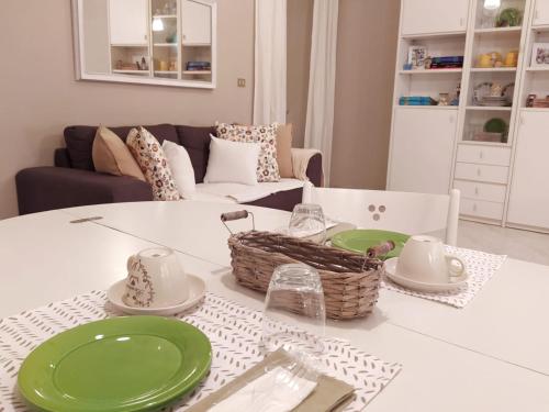 a living room with a white table with green plates at A due passi dal mare in Moneglia