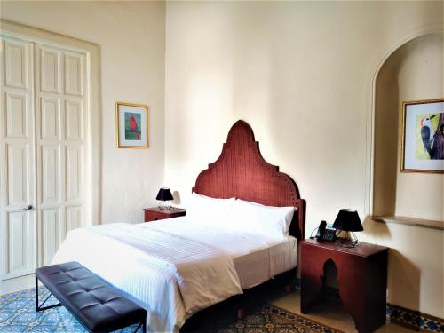 1 dormitorio con 1 cama grande y cabecero de madera en Hotel Boutique La Casona by Kavia en Mérida