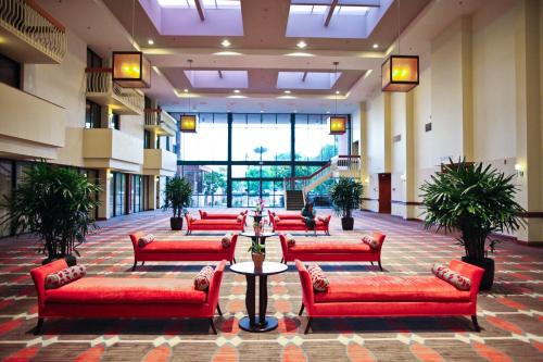 a lobby with red couches in a building at Ontario Airport Hotel & Conference Center in Ontario