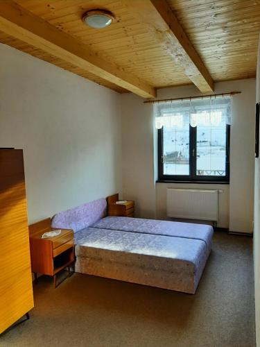 a bedroom with a large bed and a window at Apartmány-Zámecký Restaurant in Jindřichovice