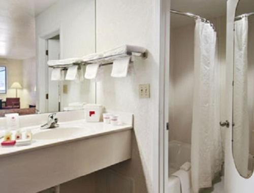 a white bathroom with a sink and a shower at Ramada Limited San Angelo in San Angelo