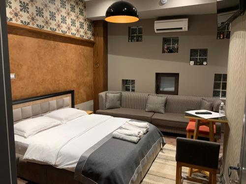 a bedroom with a bed and a couch at Guest House People in Korçë