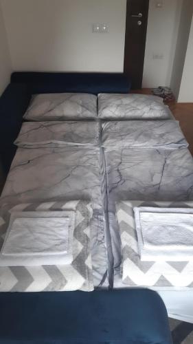 a bed with white sheets and towels on it at Apartman Luna in Valjevo