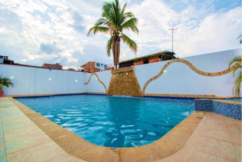 a pool on the roof of a building with a palm tree at Hotel Viena in Villeta