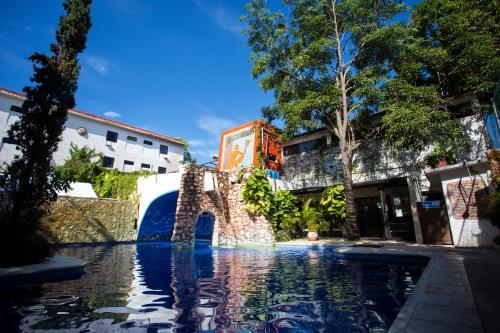 una piscina de agua con un puente y edificios en Hotel Xbalamqué & Spa Cancún Centro, en Cancún
