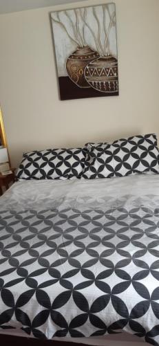 a bed with a black and white comforter at Donegal church view close to chaple st leonards in Chapel Saint Leonards