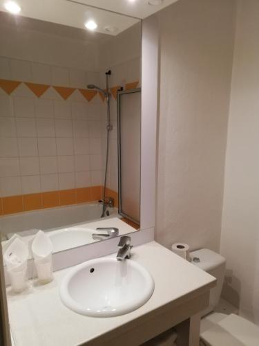 une salle de bain avec un lavabo et une baignoire dans l'établissement La Poularde, à Louhans