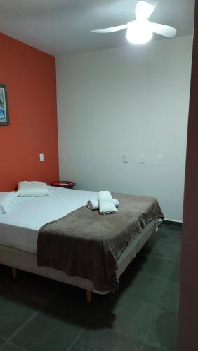 a bedroom with a bed with two towels on it at Pousada Casa Doce Vida in Águas de Lindóia