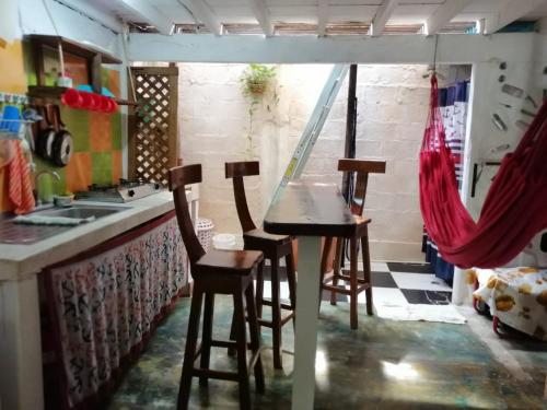 a kitchen with a counter and stools in a room at Hospedaje Pirata Express in Capurganá