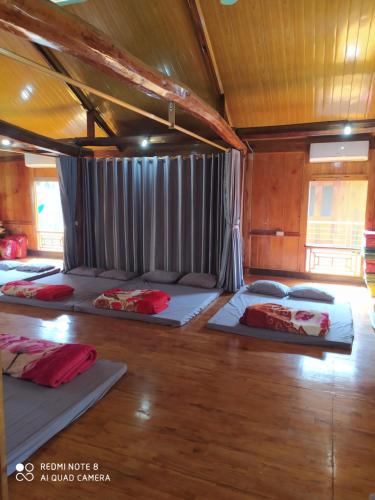 a room with four beds on the floor at Cò's House in Mai Chau