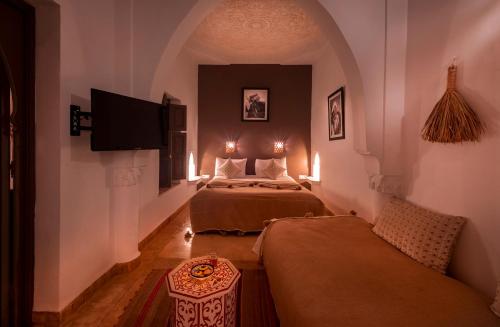 Cette chambre comprend 2 lits et une télévision. dans l'établissement Riad Loudaya & Spa, à Marrakech