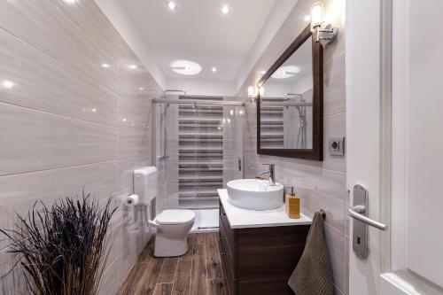 a white bathroom with a sink and a toilet at Apartman Arca in Rovinj