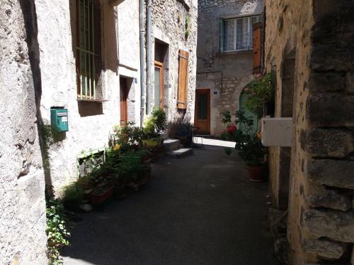an alley in an old building with potted plants at Les Terrasses de Saillans in Saillans